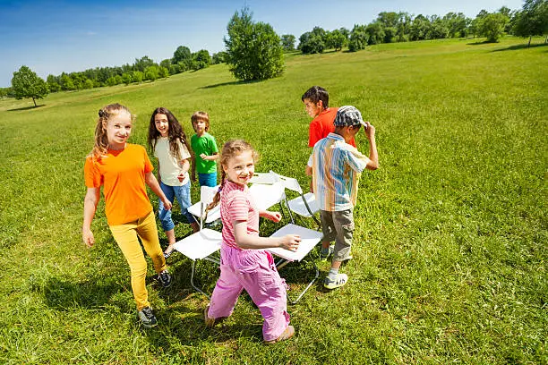 children go around playing musical chairs outside picture id507985485